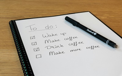 To-do list in spiral notebook with checkboxes for wake up, make coffee, drink coffee, and make more coffee